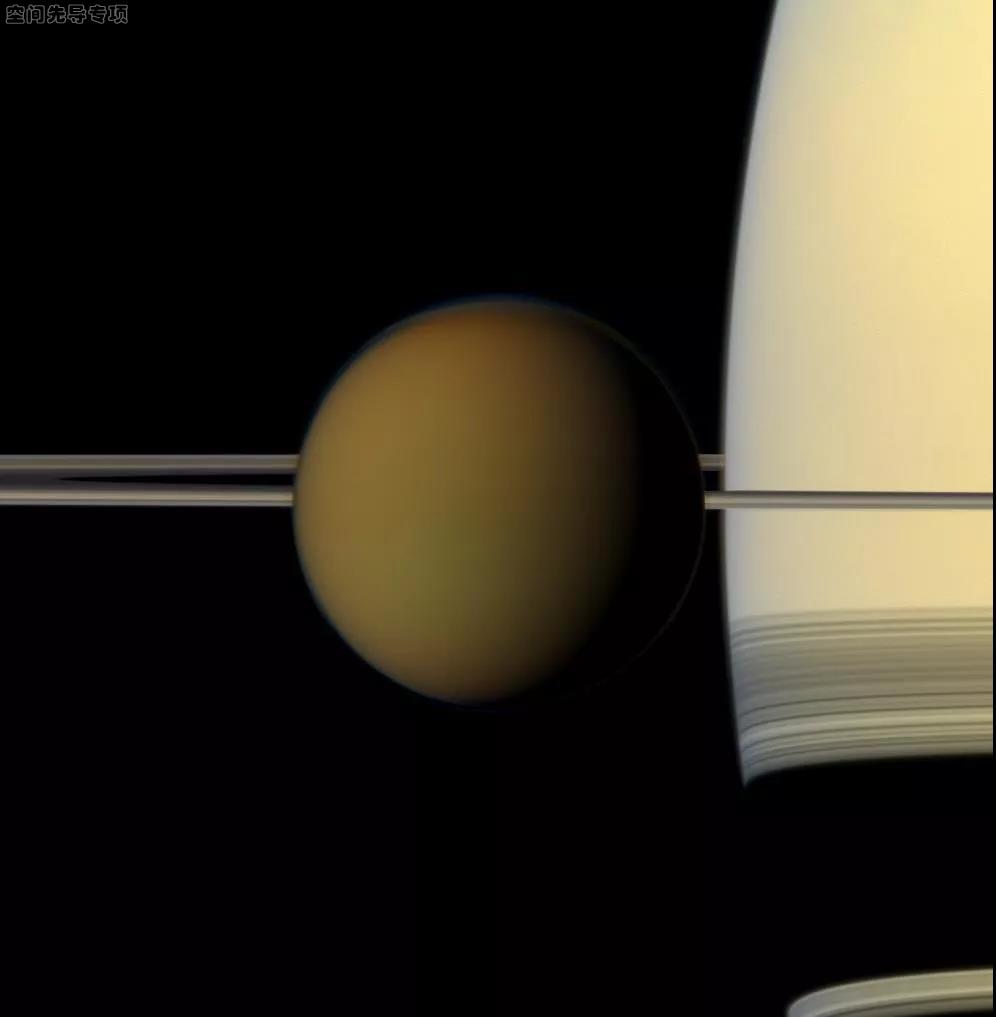 彩色球形的土卫六正从土星及其环前经过,nasa的卡西尼号探测器在2011